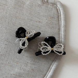 Detailed view of elegant black bow hair claws with sparkling silver beaded accents