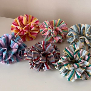 Vue détaillée de six chouchous rayés en tissu côtelé aux couleurs vives et variées