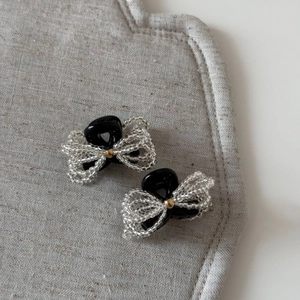 Close-up of handmade beaded bow hair clips with transparent beads and golden center bead