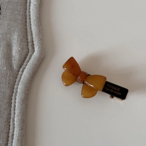 Détail d'une pince à cheveux en acétate ambré faite à la main avec lettrage doré
