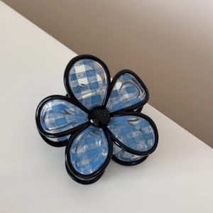 Detailed top view of blue checkered floral hair claw clip with glossy black edges
