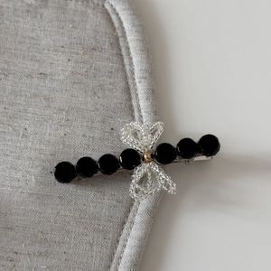 Close-up of elegant hair claw clip with black faceted beads and a woven bead bow