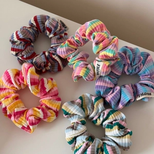 Lot de cinq chouchous en tricot à rayures colorées pour coiffure sur fond blanc éclatant