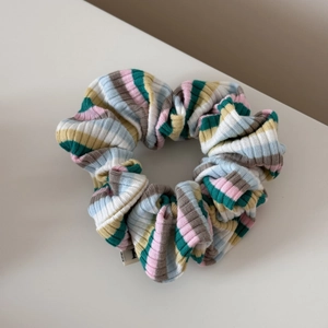Gros plan sur un chouchou en maille rayée montrant la texture côtelée et le tissu doux