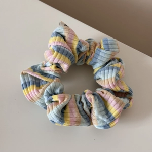 Détail d'un chouchou rayé couleur bonbon avec texture côtelée douce et design élastique
