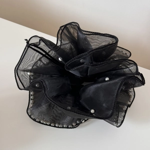 Vue détaillée du chouchou géant en organza noir avec des perles blanches élégantes