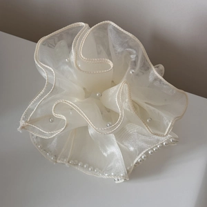 Détail d'un chouchou géant en organza crème orné de perles blanches synthétiques