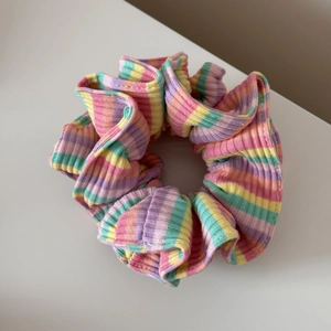 Détail montrant la texture côtelée et le tissu à rayures pastel du chouchou coloré