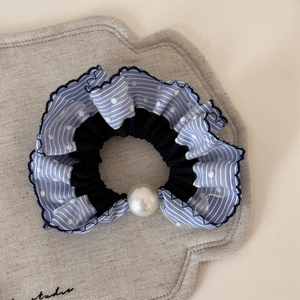 Détail du chouchou en tulle à rayures bleues avec décoration de perle élégante