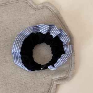 Détail du chouchou rayé bleu et velours noir montrant la texture et les couches de tissu