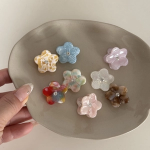 Détail de mini pinces à cheveux florales en acétate ornées de strass étincelants