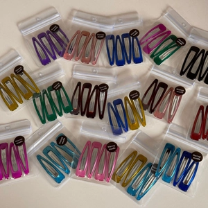 Bulk set of colorful teardrop metal snap hair clips in transparent brand packaging