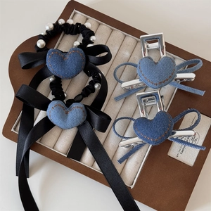 Set di accessori per capelli con cuori in denim e fiocchi esposti in un vassoio per gioielli