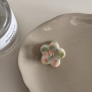 Vue détaillée de la pince à cheveux fleur en acétate avec carreaux verts et cristal