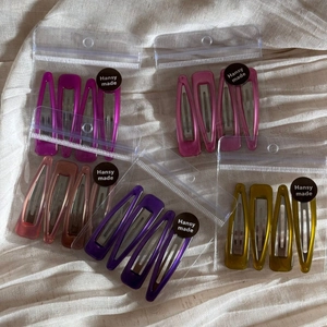Detail of colorful triangle and teardrop hair clips in transparent plastic bags