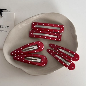Red and white polka dot hair clip set with rectangle and waterdrop shapes on a ceramic dish