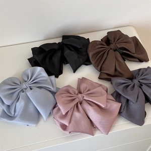 Elegant multi-layer satin bow hair claw clips set in five colors on a white surface