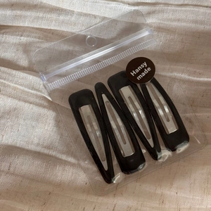 Close-up of 4-piece set of black glossy BB hair clips in branded Hansy Made packaging