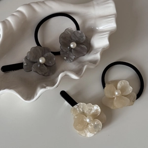 Detail of acetic acid flower hair clips and ties with pearls and sparkling rhinestones