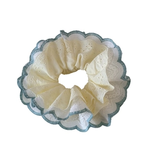 Mint green lace scrunchie with floral embroidery and creamy white fabric texture