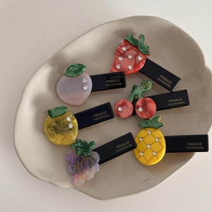 Détail de pinces à cheveux fruits avec strass montrant la gravure France Handmade