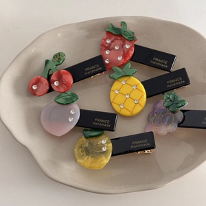 Lot de barrettes à cheveux aux fruits avec fraise pêche et raisin sur plateau céramique