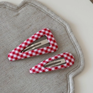 Close-up of red and white gingham fabric hair clips with triangular and teardrop shapes