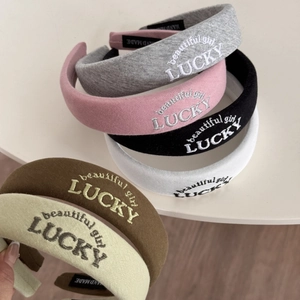 Detail of LUCKY embroidered thick sponge headbands in various colors with fabric texture