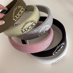 Stacked variety of thick sponge headbands featuring lucky embroidery in various colors