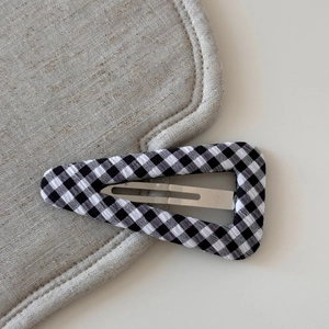 Detail shot of a Gingham fabric wrapped triangle BB hair clip with silver metal snap
