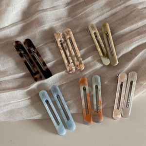 Detailed macro view of acetate hair clips in six different marble and tortoiseshell patterns
