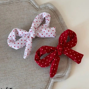Lot de barrettes à cheveux avec nœud à pois rouges et blancs sur fond textile doux