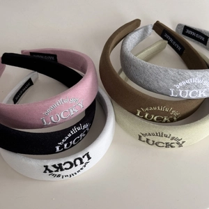 Detail view of colorful padded headbands featuring embroidered LUCKY lettering and soft fabric