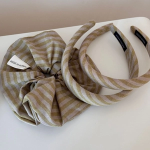 Nahaufnahme des dreiteiligen beige gestreiften Haarschmuck-Sets mit Etiketten