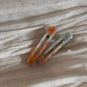 Close-up of marble pattern acetate hair clips with silver metal grip on fabric