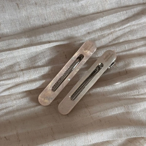Detailed macro view of handmade acetate hair clips with fine glitter and creamy finish