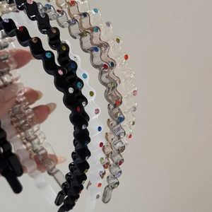 Close-up of wavy headbands with colorful rhinestones in black, white and grey colors