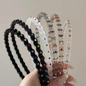 Detail of colorful rhinestones on wavy resin headbands in five elegant various colors
