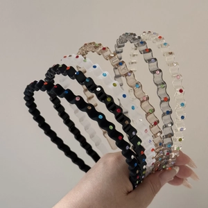 Detail showing various colors of wavy headbands with sparkling colored rhinestones
