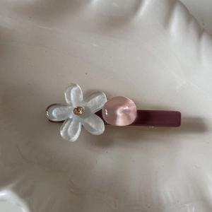 Vista detallada de la pinza para el cabello con flor de color caramelo y perla de resina rosa
