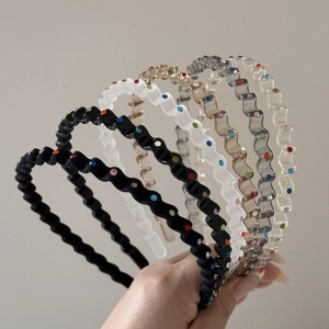 Close-up of wavy non-slip headbands with colorful rhinestones in five diverse colors