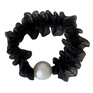 Elegante elastico in tulle nero con una grande perla bianca su sfondo bianco pulito