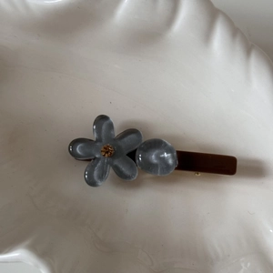 Detalle de la pinza para el cabello de flores en colores pastel con textura de perla