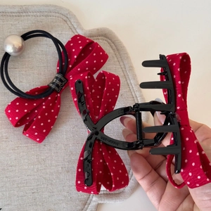 Détail de l'ensemble pince à cheveux à pois rouges avec nœud, perle et griffe noire