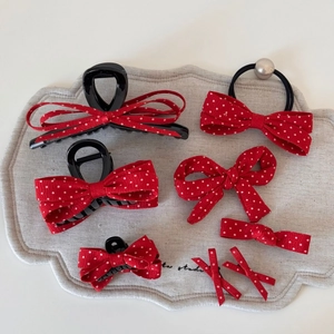 Détail de l'ensemble de barrettes à nœuds rouges à pois et élastiques à perles chic