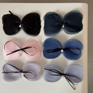 Détail de barrettes nœuds en mesh multicouches avec perles et longs rubans