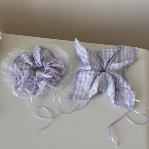 Close-up of purple plaid scrunchie and bow hair tie with white lace edges and ribbons