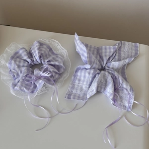 Detailed view of purple plaid scrunchie with white lace edges and lilac silk ribbons