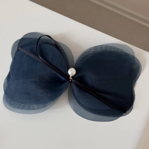 Détail de la barrette à nœud multicouche en résille bleu marine avec perle blanche