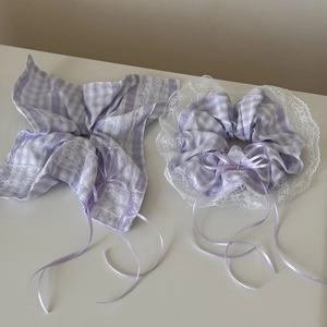 Detailed texture of purple plaid scrunchie and large bow hair clip with white lace trim